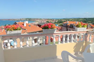 a balcony with flowers in white pots on it at Hotel Bobchev in Sozopol