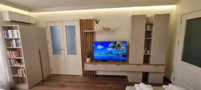 a living room with a flat screen tv on a cabinet at Kate`s Place in Burgas City