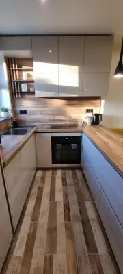 a kitchen with white cabinets and a wooden floor at Kate`s Place in Burgas City