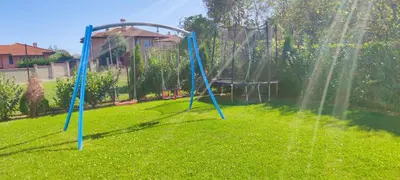 a garden with a swing set in the grass at Casa Alegra in Bliznatsi