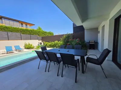a patio with a table and chairs next to a pool at Villa Felicity, private pool with heating and salt water in Lozenets