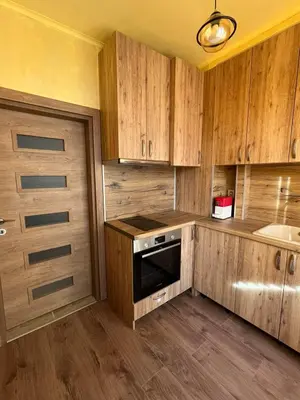 a kitchen with wooden cabinets and a sink and a stove at Varna Top Central Apartment-Tulip in Varna City