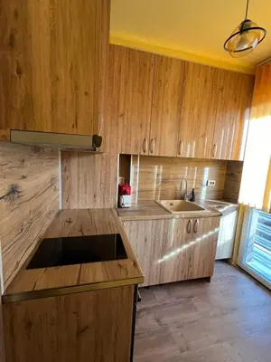 a kitchen with wooden cabinets and a sink at Varna Top Central Apartment-Tulip in Varna City