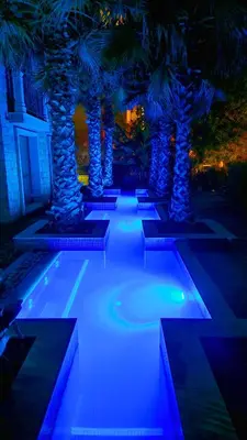 a pathway with palm trees at night with blue lights at Attractive Apartment in Sunny Beach Cascadas Family Resort in Sunny Beach