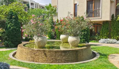 three potted plants sitting in a fountain in a yard at Attractive Studio-Apartment in Sunny Beach Cascadas Family Resort in Sunny Beach