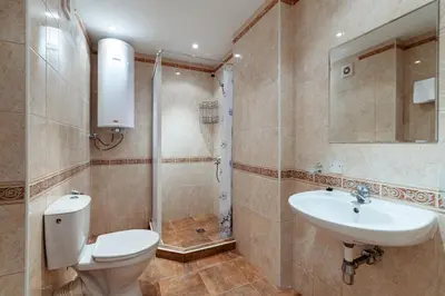 a bathroom with a toilet and a sink and a shower at Midia Holiday Apartments in Aheloy