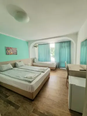 a bedroom with a bed and a desk and a sink at Hotel Char in Primorsko