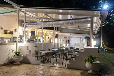 a restaurant with tables and chairs at night at Hotel Char in Primorsko