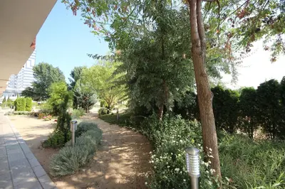 a park with trees and bushes and a sidewalk at Menada Dune Residence Apartments in Sunny Beach