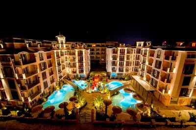 an aerial view of a building with a swimming pool at night at Menada Romance Marine Apartments in Sunny Beach