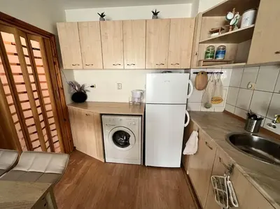 a kitchen with a white refrigerator and a washing machine at Cosy apartment near the beach with terrace & sea view in Burgas City