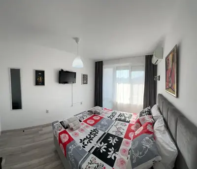a bedroom with a bed with a blanket on it at Prestige Apartment 1 in Burgas City