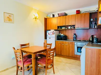 a kitchen with a table and chairs and a refrigerator at VICTORIA RESIDENCE Two Bedroom Sunny Beach in Sunny Beach