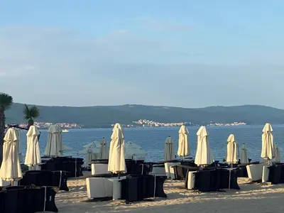 a group of tables and chairs with umbrellas on the beach at VICTORIA RESIDENCE Two Bedroom Sunny Beach in Sunny Beach