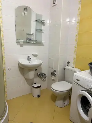 a bathroom with a toilet and a sink and a washing machine at Sunset Apartment Pomorie in Pomorie