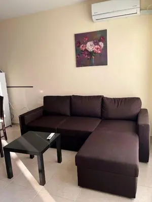 a living room with a brown couch and a table at Sunset Apartment Pomorie in Pomorie
