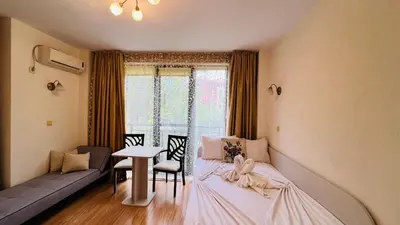 a room with a bed and a table and a window at Amara В 10 Sunny Beach in Sunny Beach