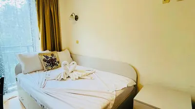 a white bed with a bow on it in a room at Amara В 10 Sunny Beach in Sunny Beach