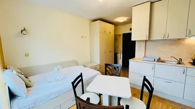a room with a bed and a table and a kitchen at Amara В 10 Sunny Beach in Sunny Beach