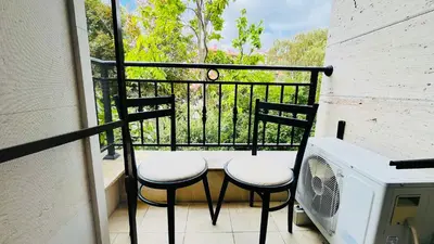 a balcony with two chairs and a microwave at Amara В 10 Sunny Beach in Sunny Beach