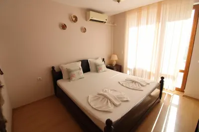 a bedroom with a bed with white sheets and pillows at Prestige Fort Beach - Menada Apartments in Sveti Vlas