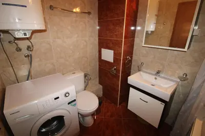 a bathroom with a washing machine and a sink at Prestige Fort Beach - Menada Apartments in Sveti Vlas