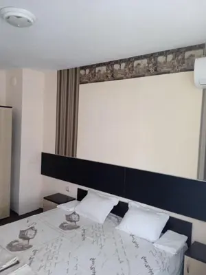 a bedroom with a bed with a black headboard at Къща за гости in Primorsko