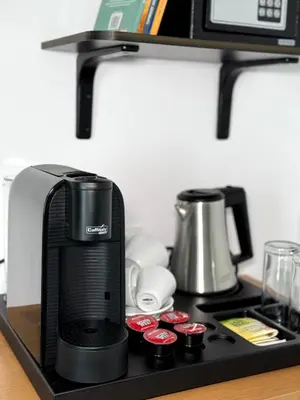a black coffee maker on a black shelf at Hotel Mistral in Nesebar