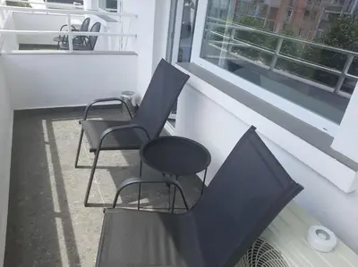 two black chairs on a balcony with a window at Hotel Mistral in Nesebar