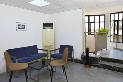 a waiting room with blue chairs and a table at Hotel Mistral in Nesebar