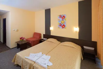 a hotel room with a bed and a red chair at Yavor Palace Hotel - All Inclusive in Sunny Beach