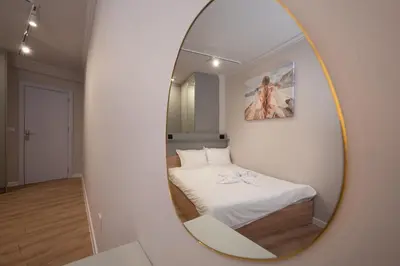 a mirror reflecting a bedroom with a bed in a room at Central Apartments with Patio Close to Sea in Varna City