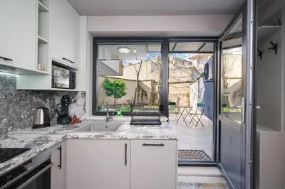 a kitchen with a sink and a large window at Central Apartments with Patio Close to Sea in Varna City