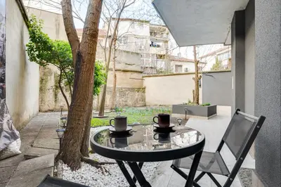 a glass table and a chair on a patio with a tree at Central Apartments with Patio Close to Sea in Varna City