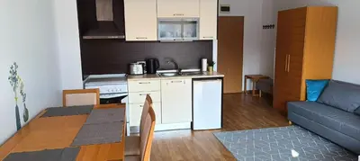 a kitchen and living room with a table and a couch at Apartment Victoria Hotel & SPA Aheloy in Kableshkovo