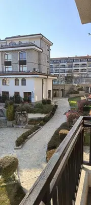 a walkway leading to a large building with a courtyard at Apartment Victoria Hotel & SPA Aheloy in Kableshkovo