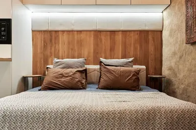 a bedroom with a bed with a wooden headboard at Studio in the Center of Burgas next to the See in Burgas City