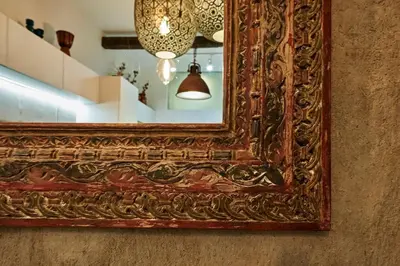 a mirror on a wall with a lamp and a light at Studio in the Center of Burgas next to the See in Burgas City