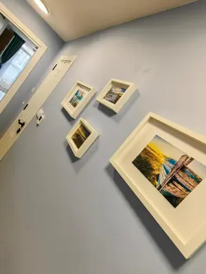 a group of framed photographs on a wall in a museum at Апартамент BLUE CREAM in Burgas City