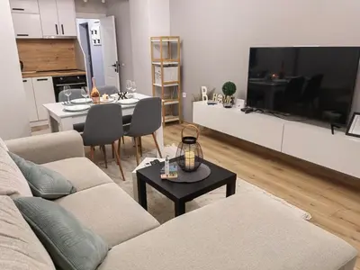 a living room with a couch and a table and a kitchen at Апартамент BLUE CREAM in Burgas City