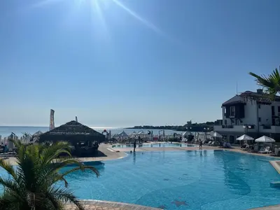 a large swimming pool next to a beach with buildings at Heritage in Oasis Resort Lozenets in Lozenets