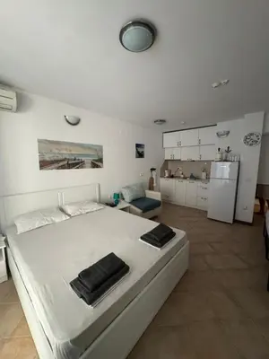 a white bedroom with a white bed and a refrigerator at Heritage in Oasis Resort Lozenets in Lozenets
