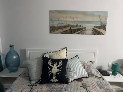 a bed with pillows and a painting on the wall at Heritage in Oasis Resort Lozenets in Lozenets