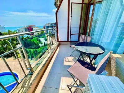 a balcony with a table and chairs and the ocean at Apartament w Bułgarii in Sveti Vlas