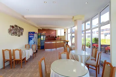 a restaurant with tables and chairs and a counter at Sunny Flower Family Hotel in Sunny Beach