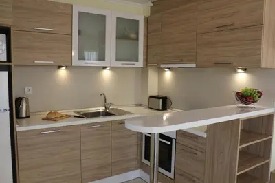 a kitchen with wooden cabinets and a sink at Vello Apartments in Byala