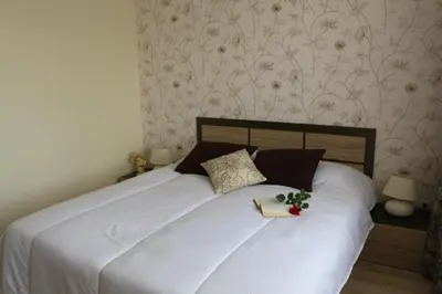 a bedroom with a white bed with a book on it at Vello Apartments in Byala