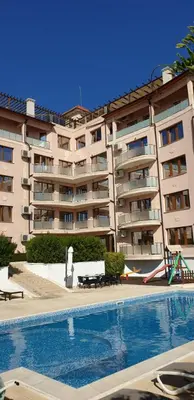 a large apartment building with a swimming pool in front of it at Vello Apartments in Byala