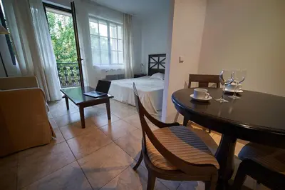 a room with a bed and a table and chairs at The Cliff Lux Apartment Obzor, Burgas, Bulgaria in Obzor