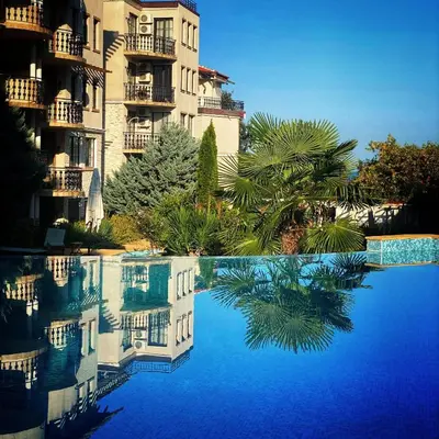a reflection of a building in a swimming pool at The Cliff Lux Apartment Obzor, Burgas, Bulgaria in Obzor